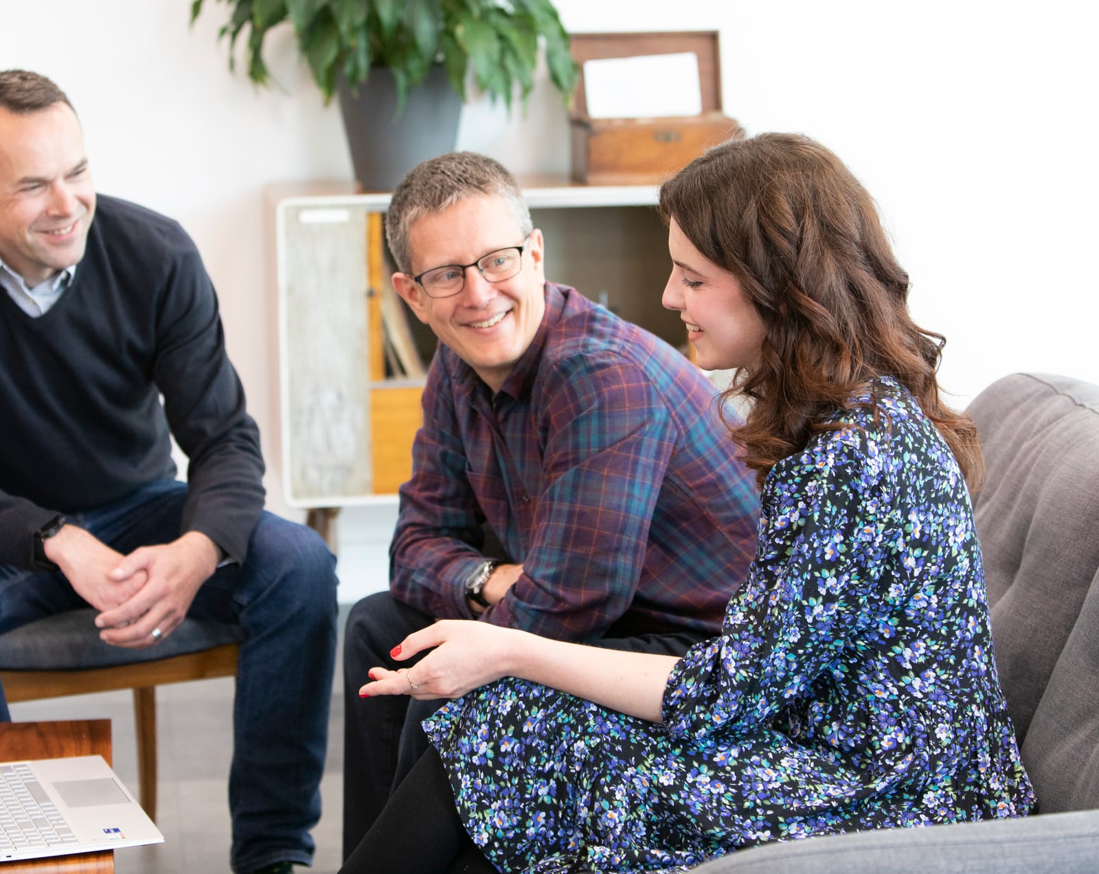 Three Cyberlogical colleagues smiling and talking together in a bright office